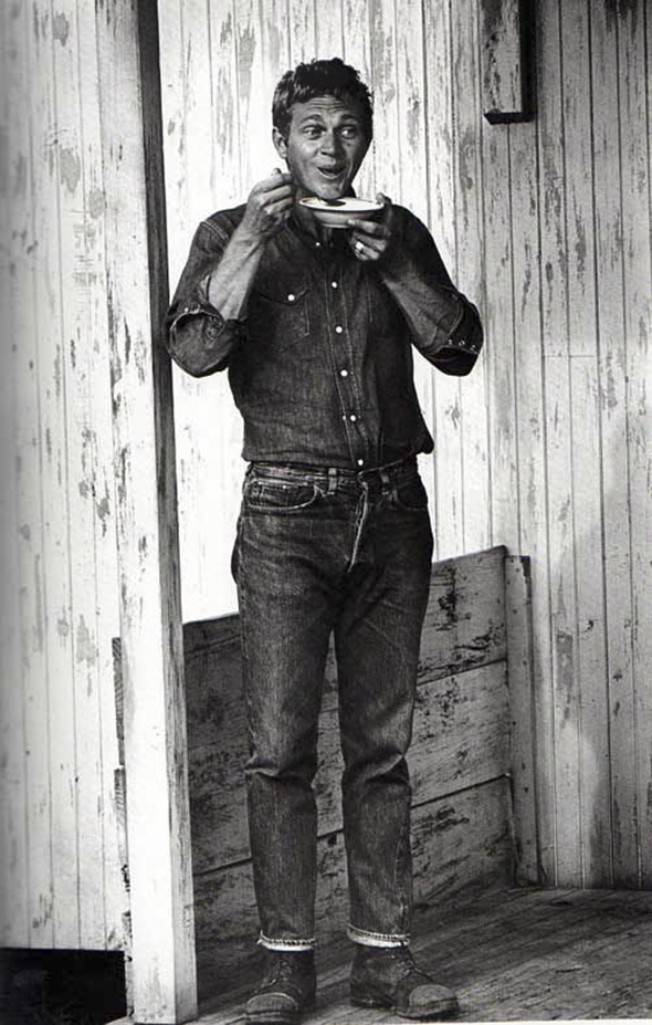 Steve Mcqueen look et amour pour la moto par John Dominis. Découvrez sur notre Blog un article complet sur Steve McQueen. Le style Steve Mcqueen, ses voitures, ses motos et des anecdotes sur l'acteur. Un tee-shirt blanc, un Chino beige, une paire de clarks et une Triumph, le style Steve Mcqueen.